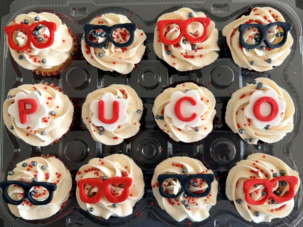 Cupcakes topped with fondant eyeglasses and the letters P, U, C and O