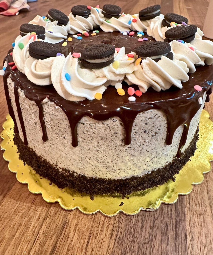 Cookies and cream cake with a chocolate drip, frosting swirls, Oreo cookies and sprinkles
