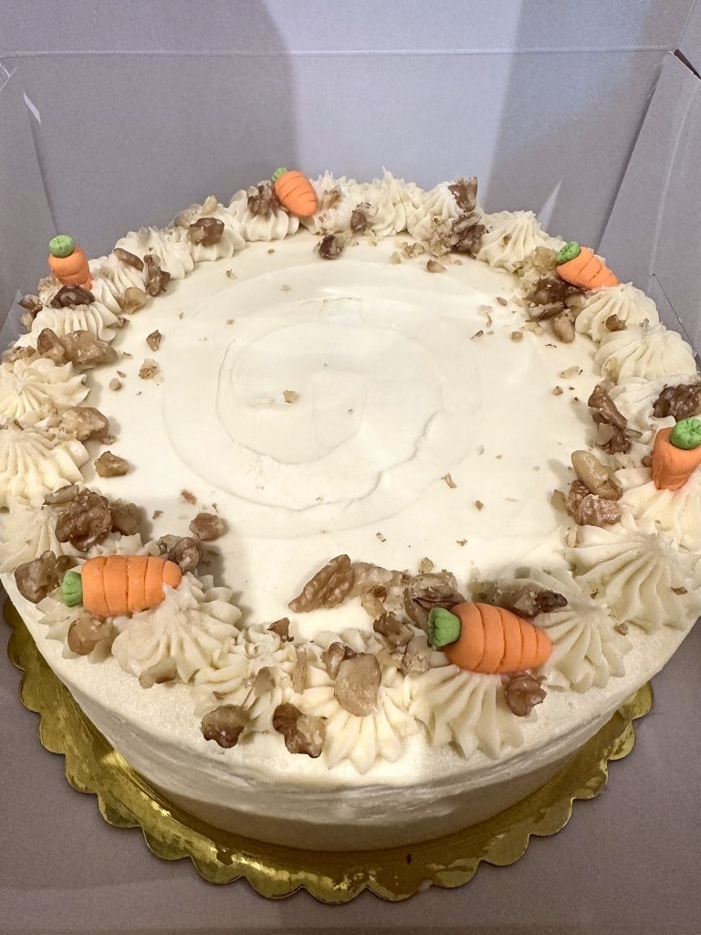 Carrot cake with cream cheese frosting, walnuts and little frosting carrots