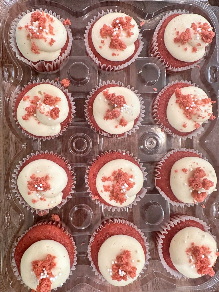 Red velvet cupcakes with cream cheese frosting and red velvet crumbs