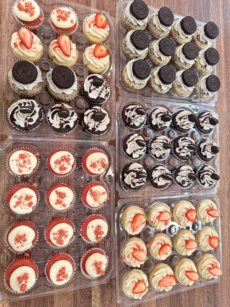 Four trays of mini cupcakes, including strawberry, Oreo and red velvet